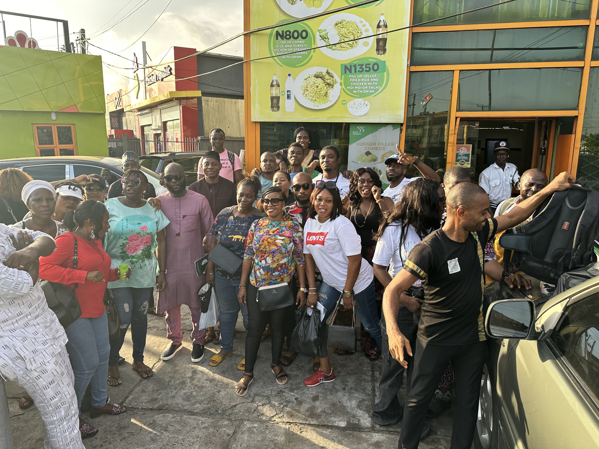 Alumni group photograph outside a community venue