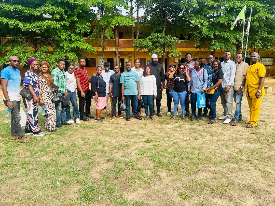 Alumni group portrait in front of school buildings