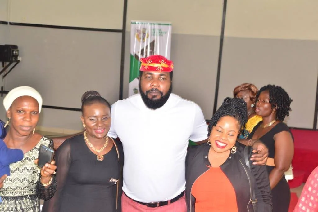 Members standing arm in arm and smiling inside the hall during the inaugural gathering.