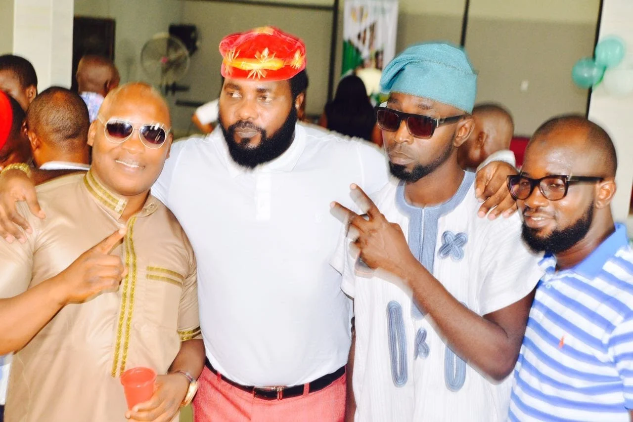 Four members posing together with arms around one another during an informal moment at the inaugural gathering.