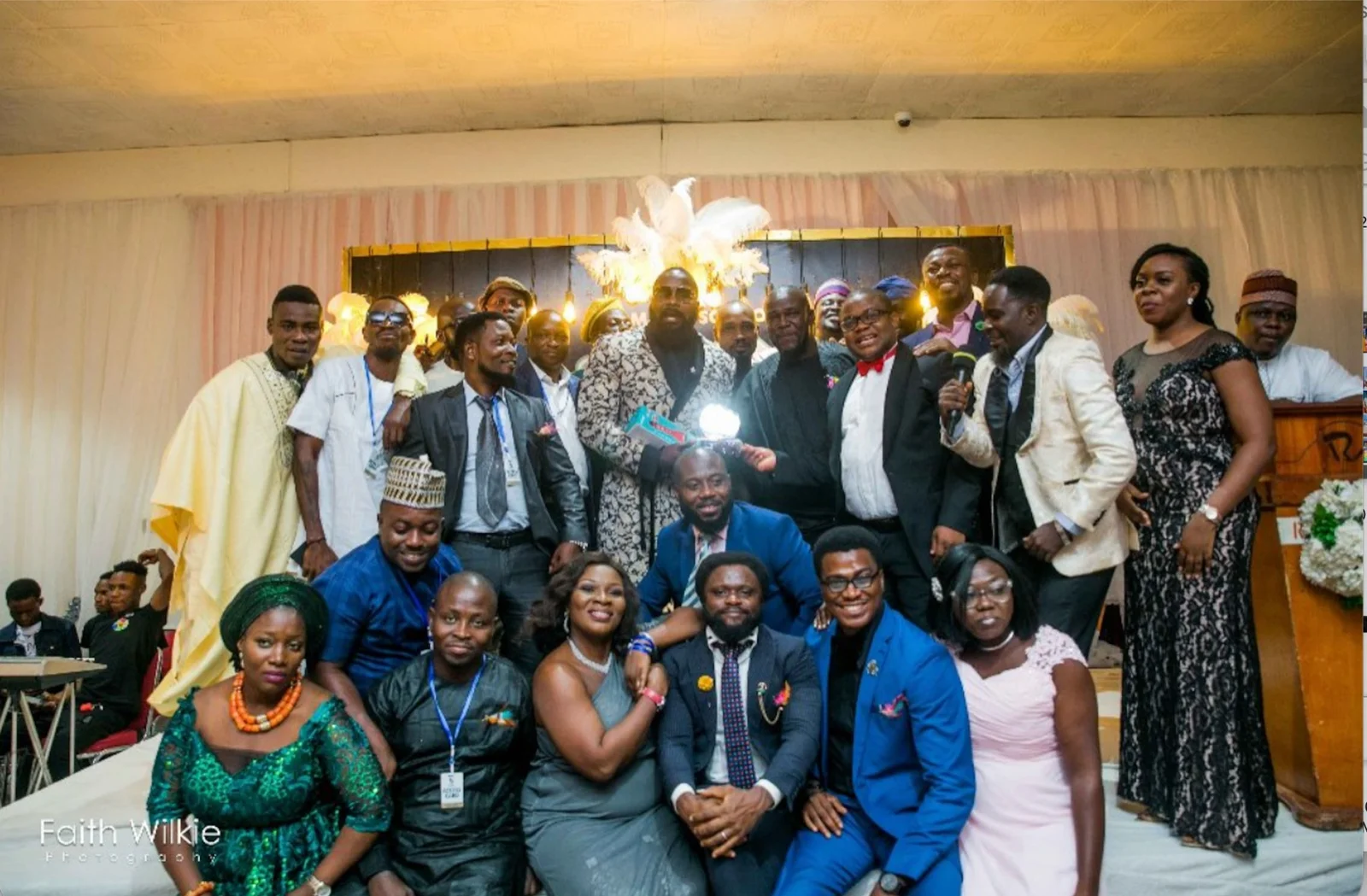 A large group of FGSCAA members in formal evening wear gathered on stage during the 2020 First Homecoming Reunion.