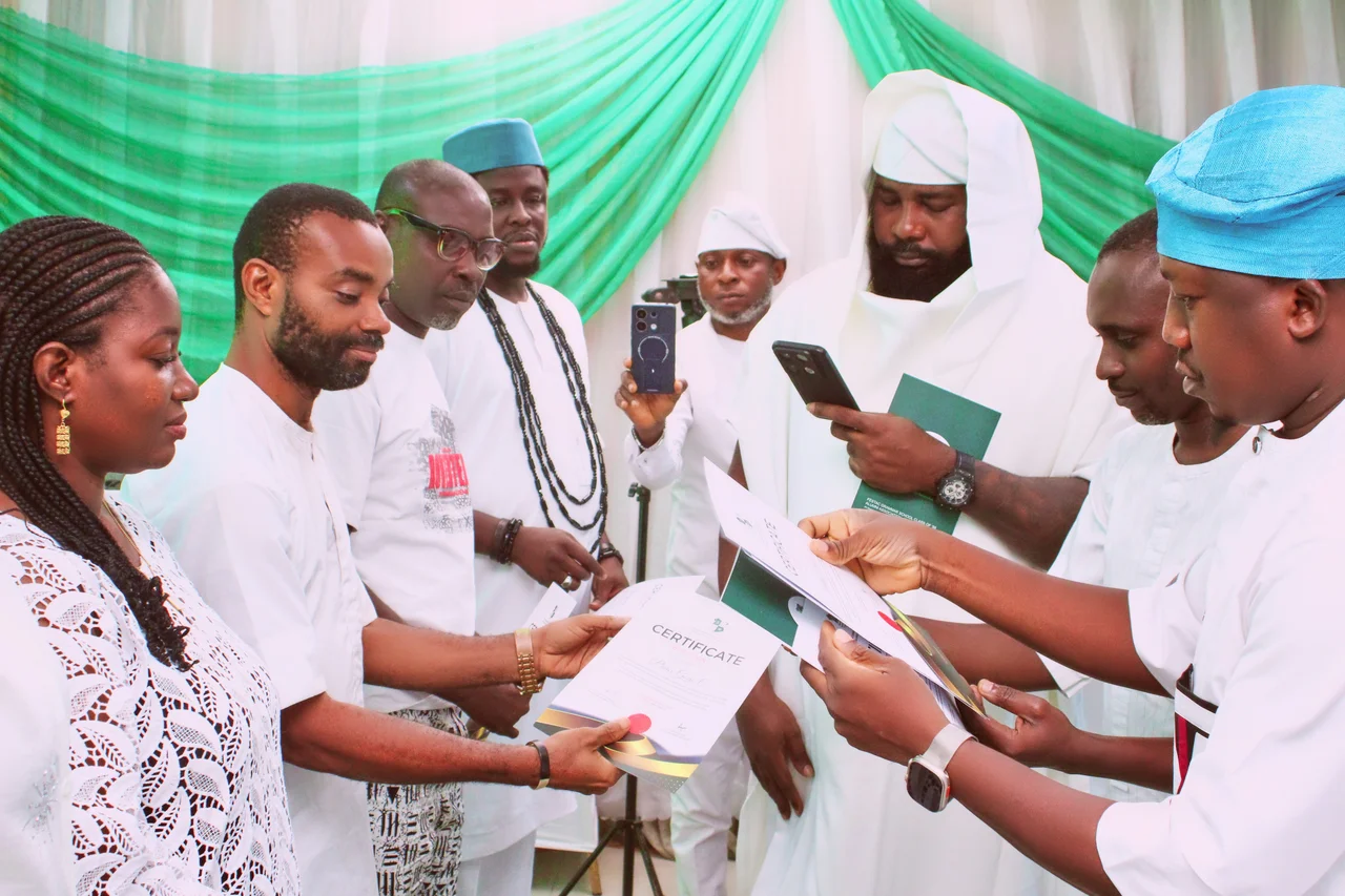 Officers in white attire holding and reading certificates during the officer confirmation at the FGSCAA swearing-in ceremony on 26 September 2026.