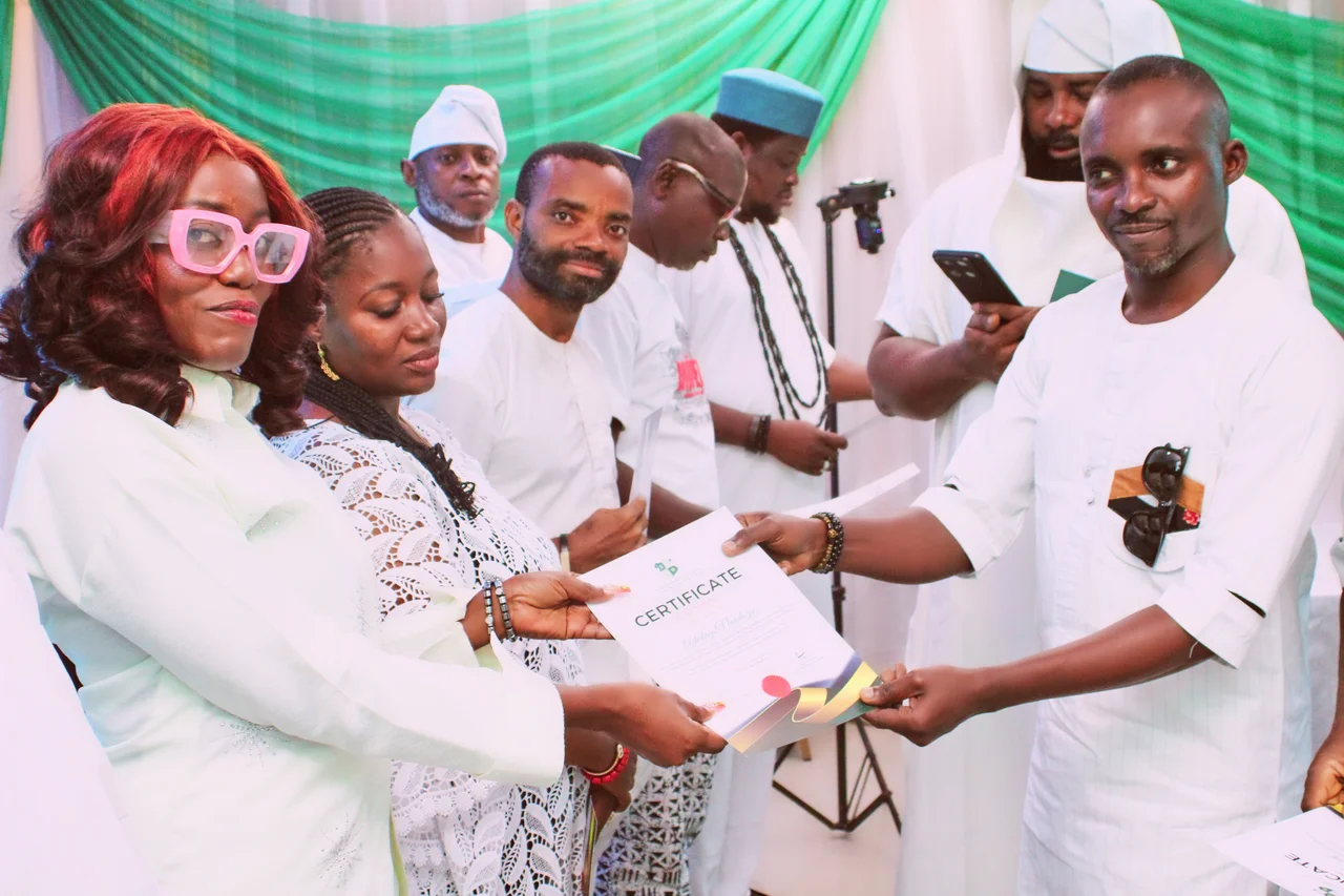 A certificate of return being handed over during the FGSCAA swearing-in ceremony on 26 September 2026, with other officers holding certificates in the background.