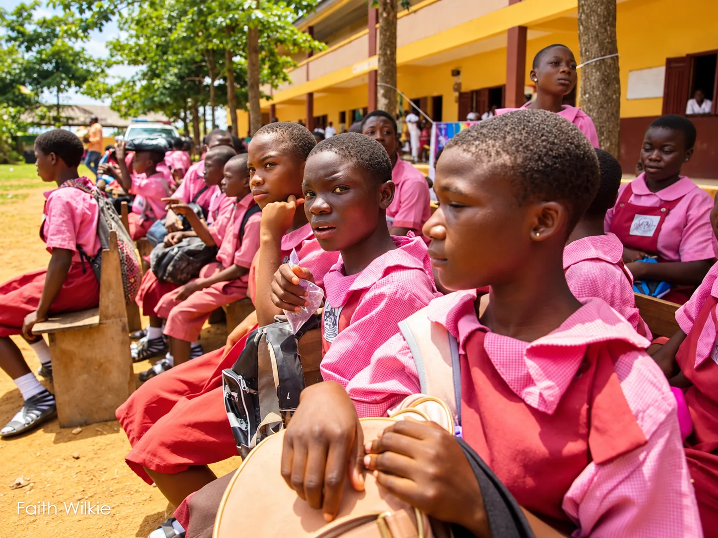 Students seated on benches in the school courtyard during the programme.