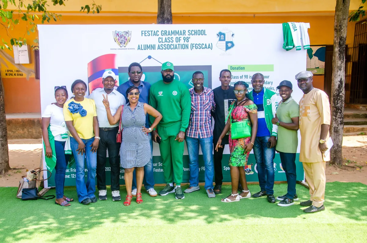 A group of FGSCAA members and school representatives pose in front of the FGSCAA Back-to-School backdrop at Festac Grammar School.