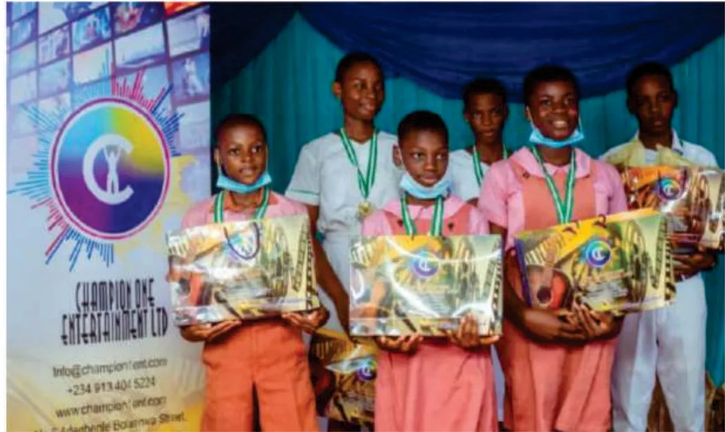 Spelling Bee finalists wearing medals and holding educational prize packs.