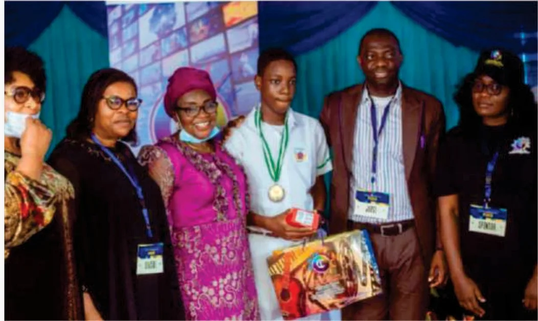 A medal-wearing award recipient standing with FGSCAA representatives and event officials after the presentation ceremony.